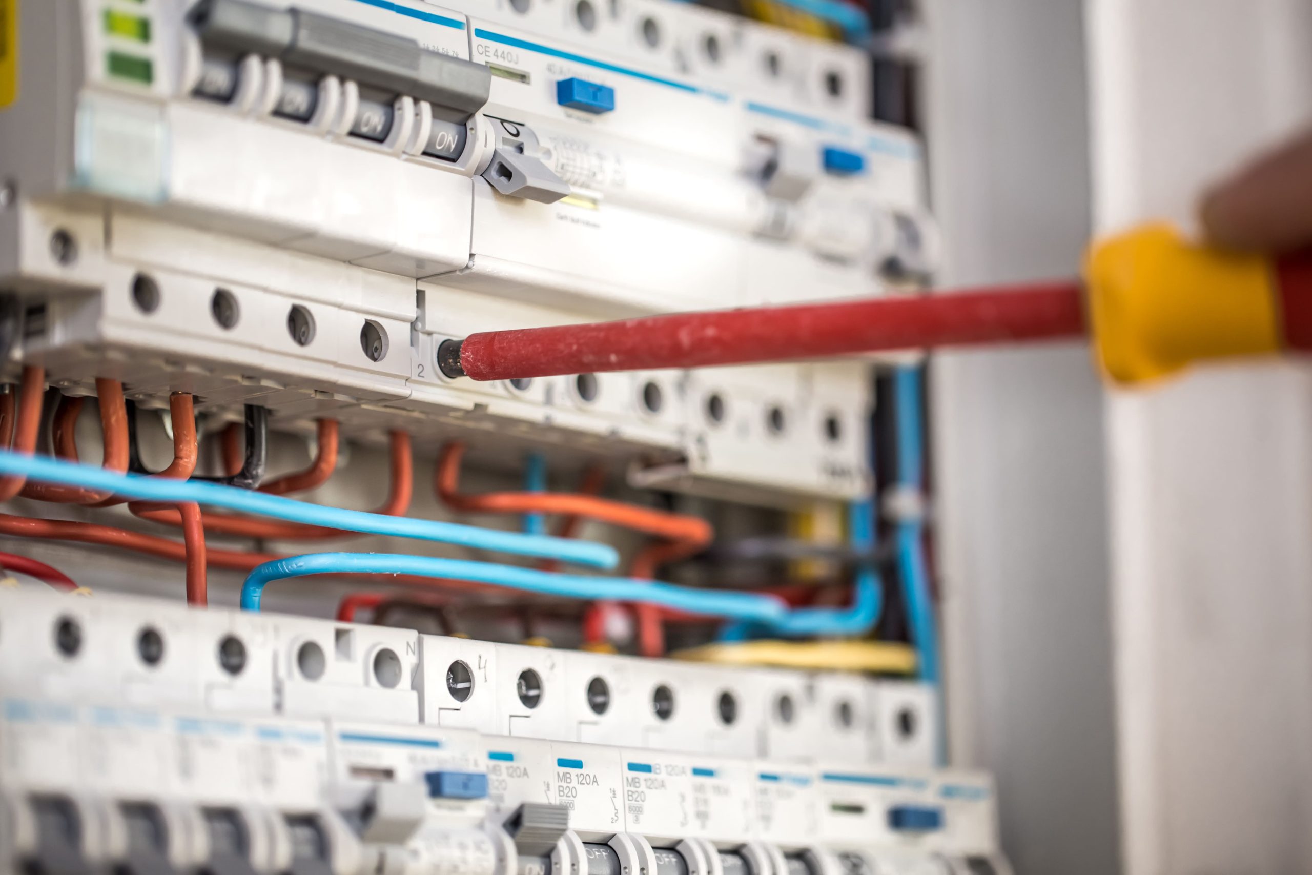 man-electrical-technician-working-switchboard-with-fuses-installation-connection-electrical-equipment-close-up
